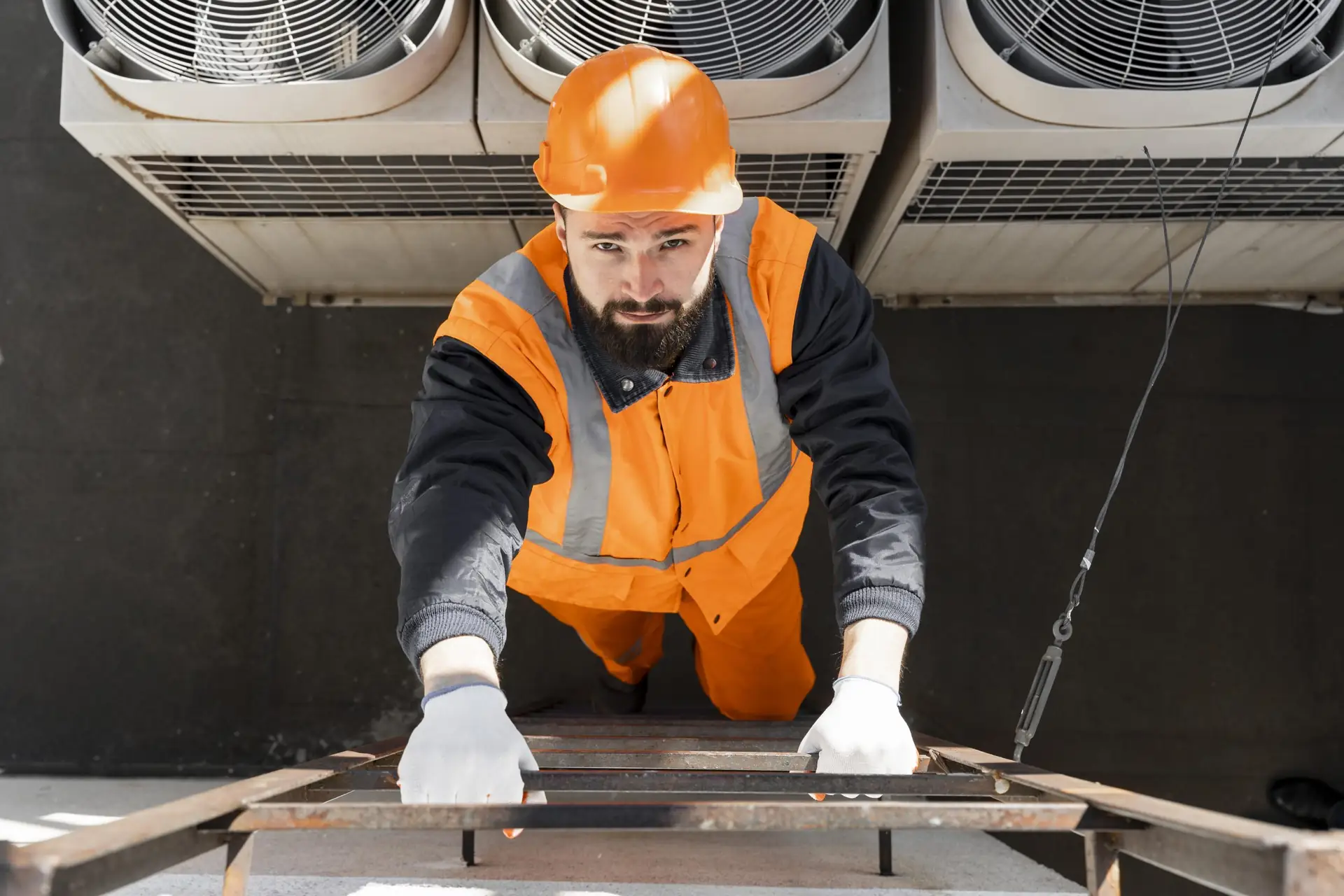 Monteur met veiligheidshelm werkt bij een installatie